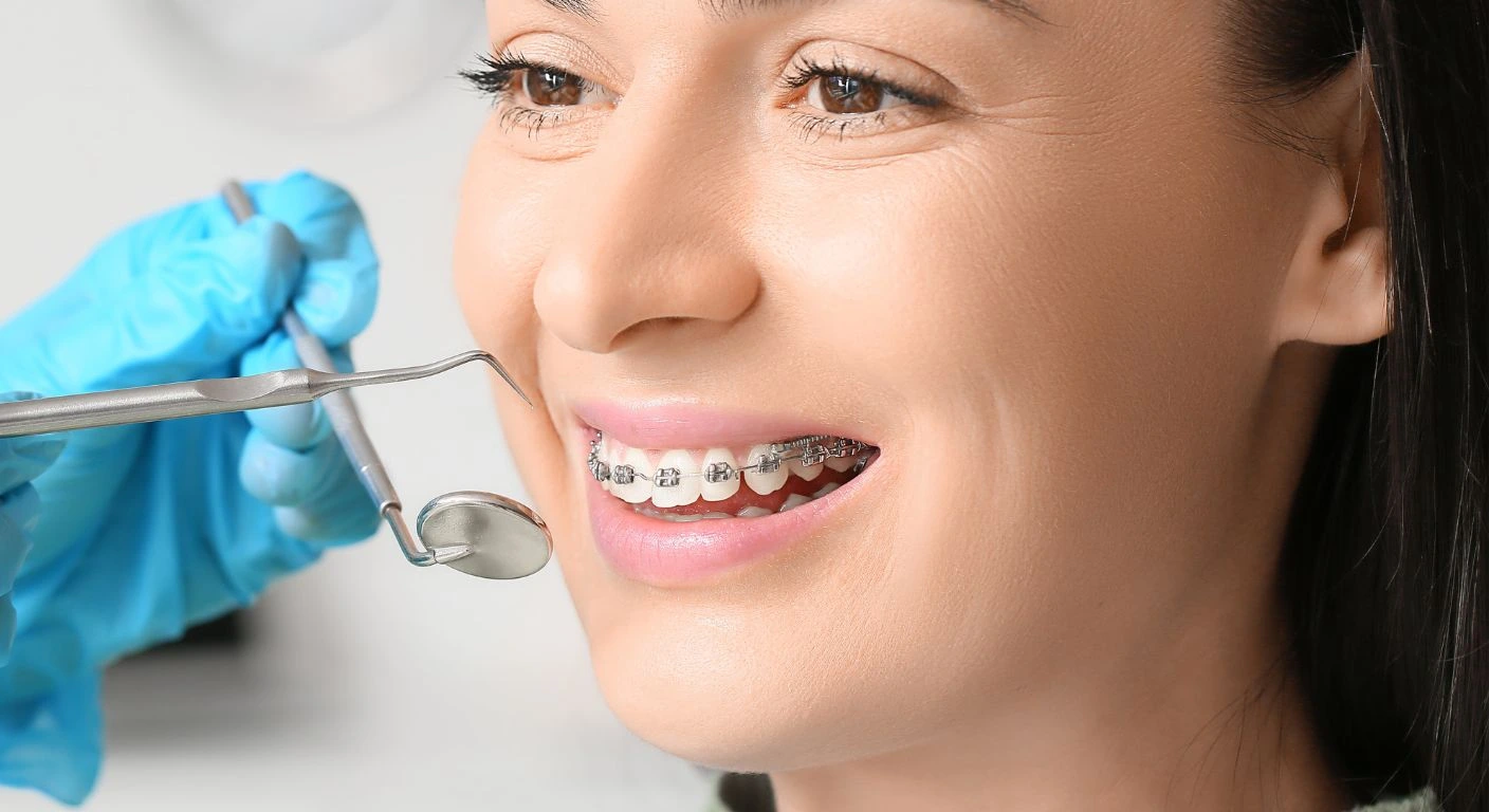 Hombre mayor sonriendo con confianza mientras muerde una pera, demostrando la funcionalidad de su tratamiento de rehabilitación oral.